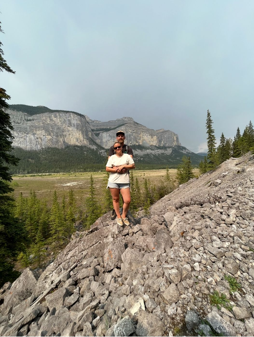 Dellie and her husband standing on a rocky slope in the Rocky Mountains